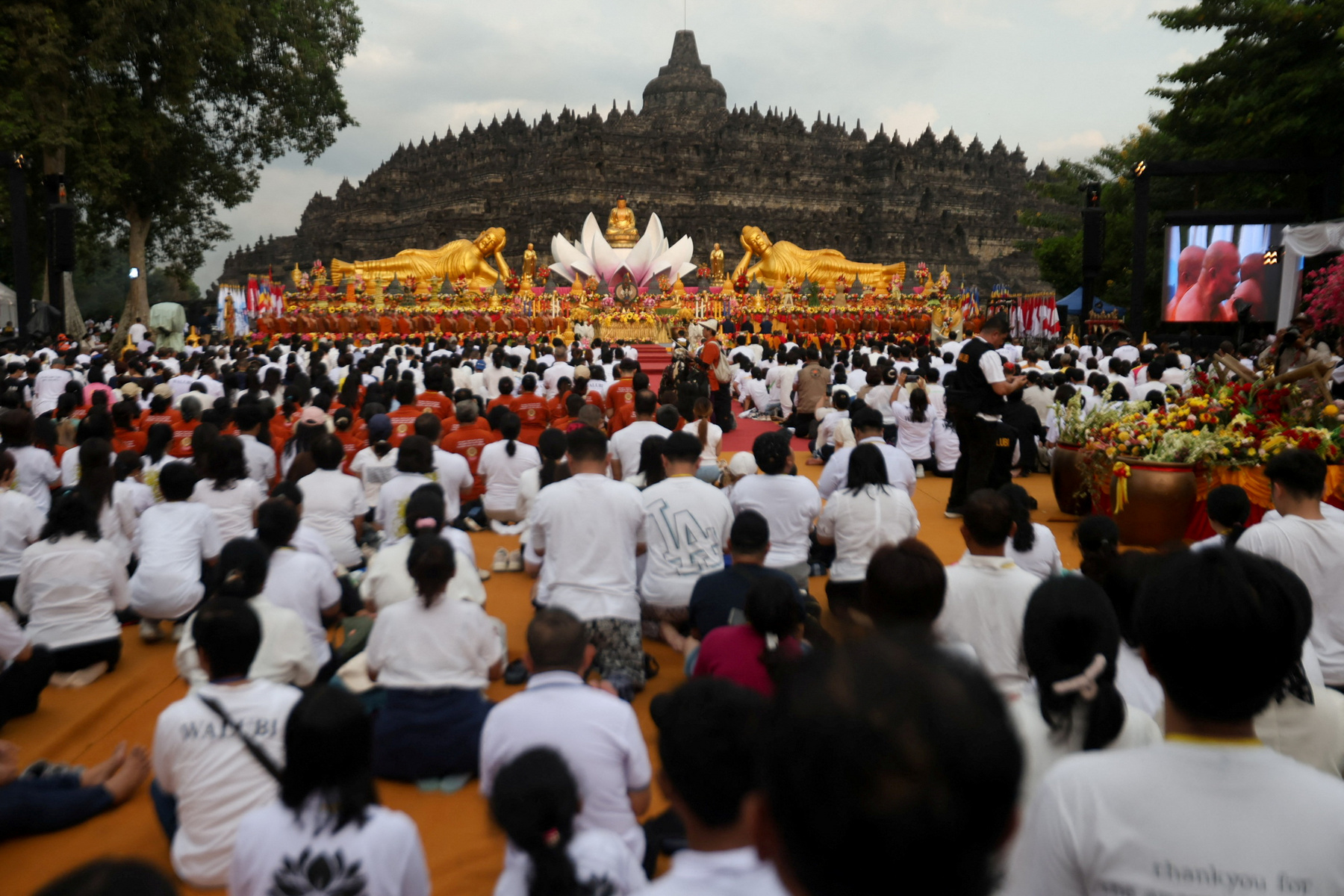 Buddhista hívők követik a kocsik felvonulását a Vesak-napi felvonulások során Malajziában 2025. május 12-én
