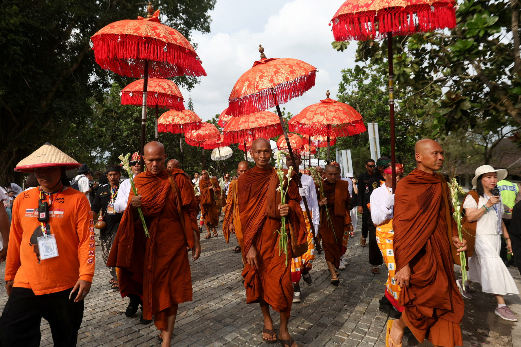 Buddhista hívők követik a kocsik felvonulását a Vesak-napi felvonulások során Malajziában 2025. május 12-én