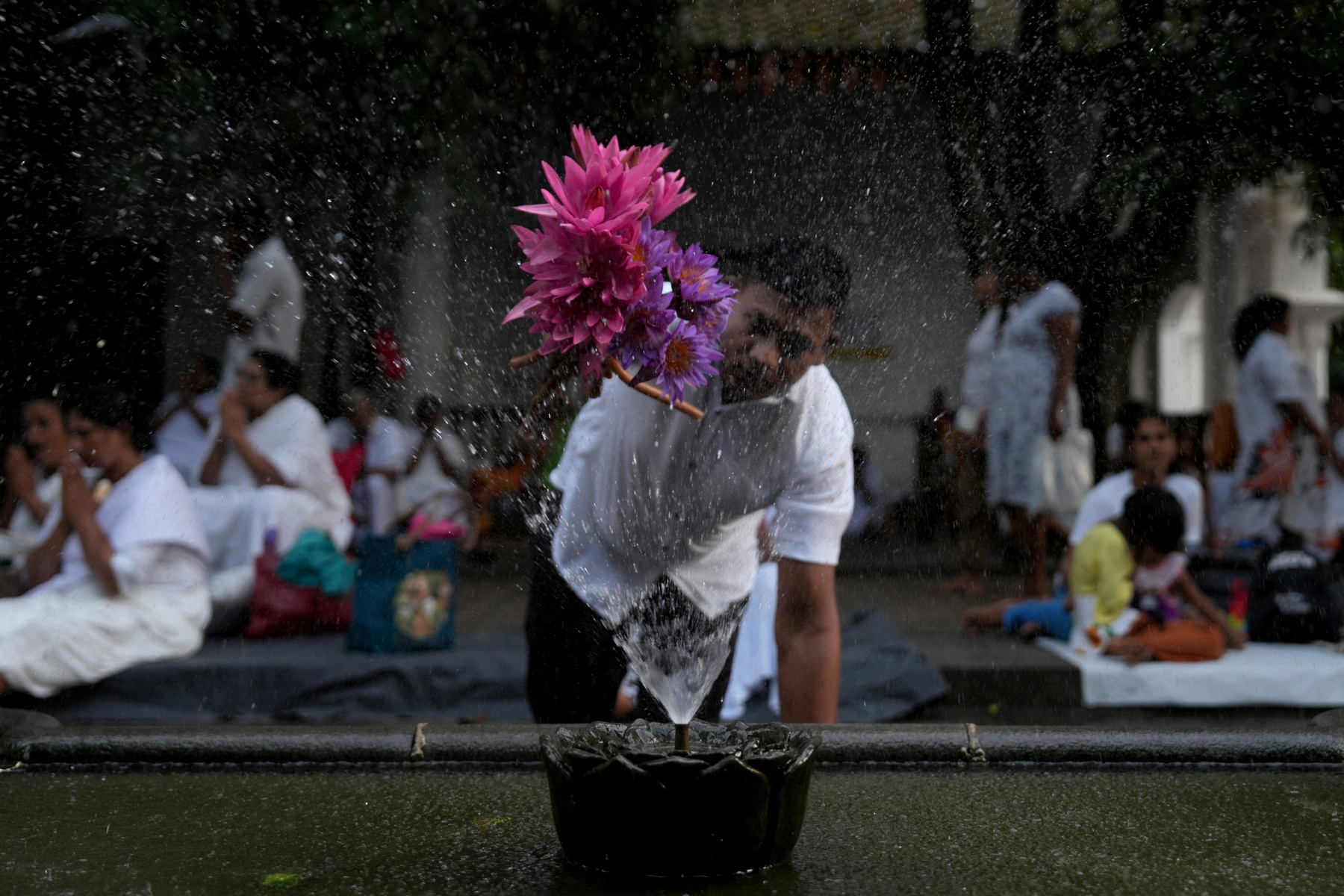Buddhista hívők követik a kocsik felvonulását a Vesak-napi felvonulások során Malajziában 2025. május 12-én