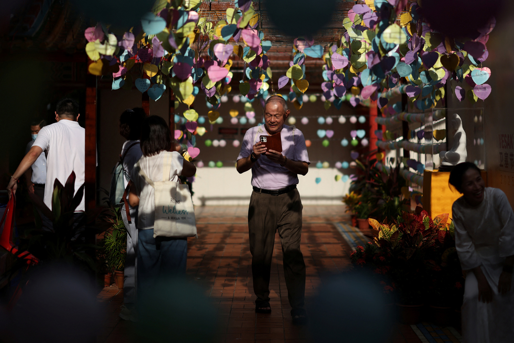 Buddhista hívők követik a kocsik felvonulását a Vesak-napi felvonulások során Malajziában 2025. május 12-én