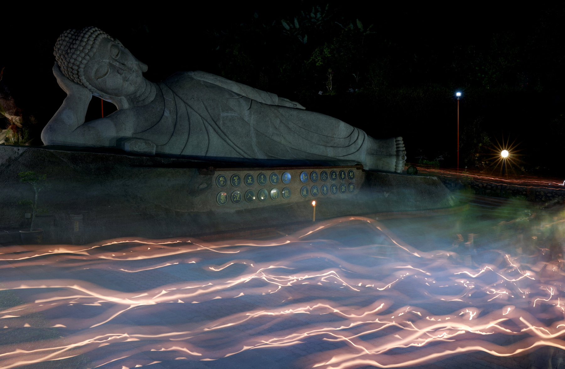 Buddhista hívők követik a kocsik felvonulását a Vesak-napi felvonulások során Malajziában 2025. május 12-én