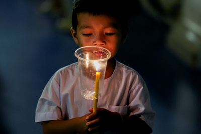 Buddhista hívők követik a kocsik felvonulását a Vesak-napi felvonulások során Malajziában 2025. május 12-én