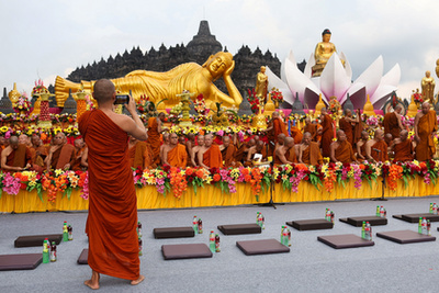 Buddhista hívők követik a kocsik felvonulását a Vesak-napi felvonulások során Malajziában 2025. május 12-én