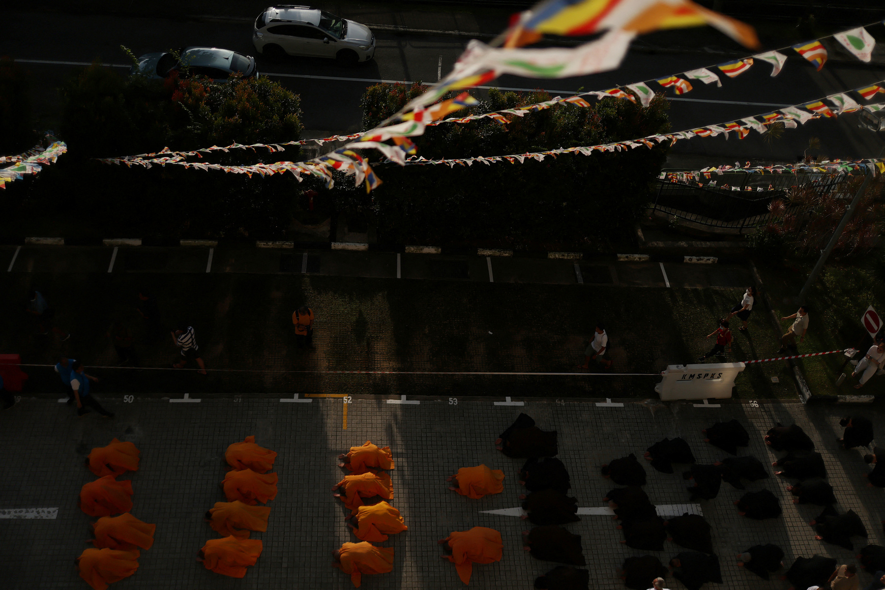 Buddhista hívők követik a kocsik felvonulását a Vesak-napi felvonulások során Malajziában 2025. május 12-én