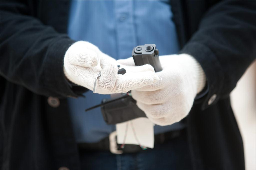 A Terrorelhárítási Központ (TEK) munkatársa egy lefoglalt pisztolyból eltávolított csavart és a csavar eltávolításához használt imbuszkulcsot tart a kezében a TEK X. kerületi telepén