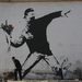 Palesztin munkás egy Banksy graffiti alatt a Gázai övezetben