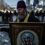 Egy ortodox pap a szentmisét celebrál a Hrushevskoho utcában álló rendőr sorfal előtt, 2014. január 31.