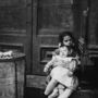 Riist újságíróként és később fotósként is főleg a legszegényebbek élete érdekelte. Ezt a kuka mellett üldögélő kislányt, aki valószínűleg a testvérére vigyáz, 1890-ben fotózta le.