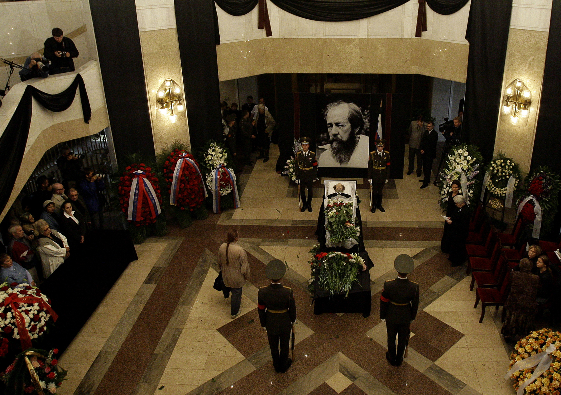Szolzsenyicin ravatala az Orosz Tudományos Akadémia kupolacsarnokában 2008. augusztus 5-én. Élete utolsó évtizedében Putyin rendszerét támogatta, ezért írófejedelemnek kijáró állami gyászszertartással búcsúztatták.
