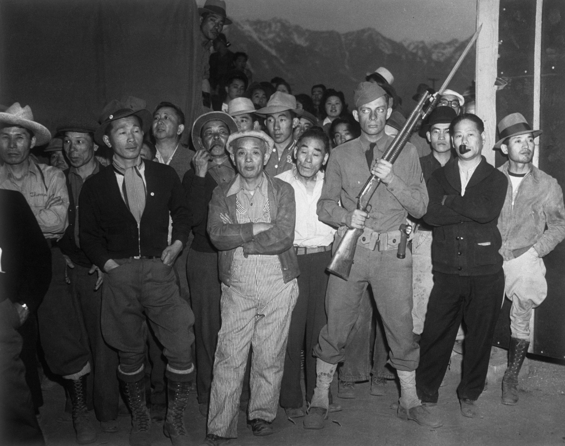 A Manzanar amerikai katonája fegyverrel a kezében őrzi a japán amerikai internáltakat 1944-ben.
