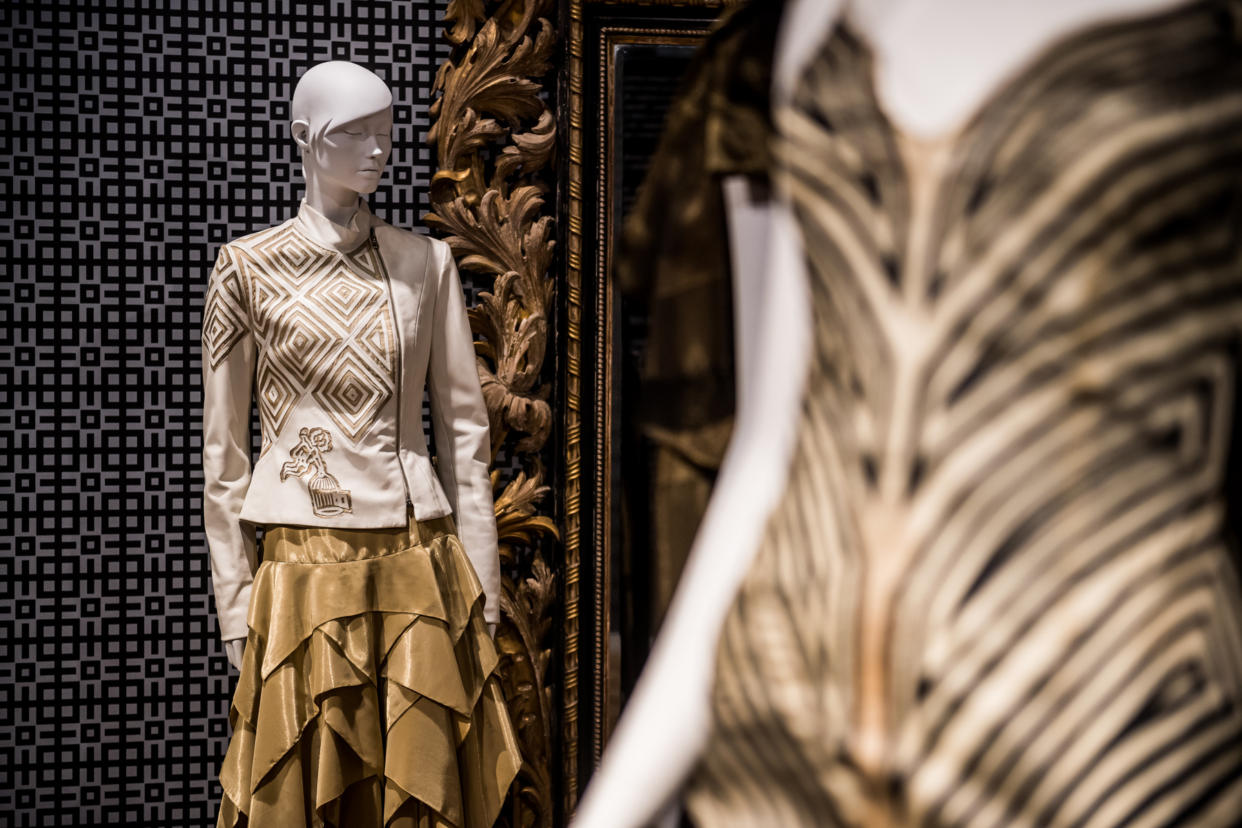 Az időszaki kiállításon megjelenő öltözékek színvilága az arany és a fekete. A kalitka motívuma XVIII. századi bútorintarziáról származik
