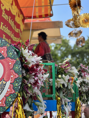 A szekér előtt táncosok, énekesek, valamint egy Krisna-völgyi ökrösszekér halad.