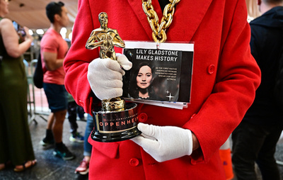 Egy Oscar-rajongó egy Oscar-díj másolattal mutatja a legjobb filmnek járó díjat 2024. március 8-án