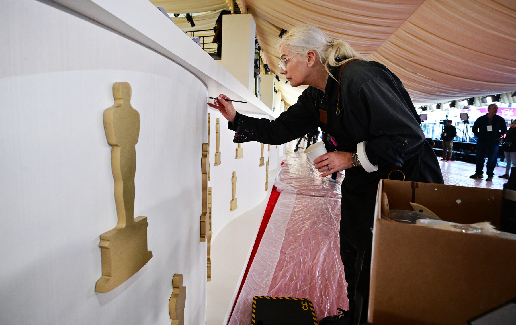 Egy Oscar-rajongó egy Oscar-díj másolattal mutatja a legjobb filmnek járó díjat 2024. március 8-án