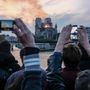 Turisták fotózzák a lángoló Notre-Dame épületét 2019. április 15-én 