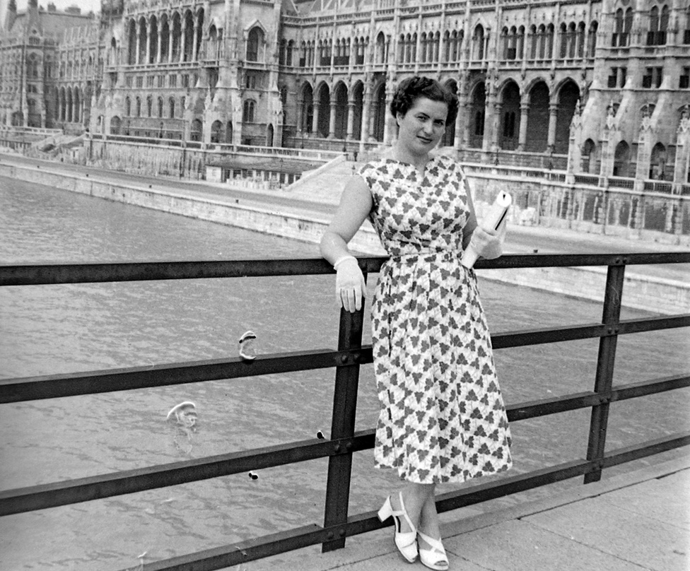 Esztergomi idill, háttérben a felrobbantott Mária Valéria híd, 1955. A zoknira húzott szandált viselő férfi a baráti Csehszlovákia felé mutat kedvesének, csak remélni tudjuk, hogy nem ellenséges szándékkal. Ennél azonban jóval érdekesebb a Mária Valéria híd torzója, ami a második világháború végétől az ezredfordulóig késztette elgondolkodásra Esztergom és a túloldali Párkány lakóit és látogatóit. Az 1895-ben átadott, Ferenc József lányáról (engedéllyel!) elnevezett hidat kétszer rombolták le. Először az első világháború után csehszlovák légionáriusok, majd a második világháború utolsó hónapjaiban visszavonuló német csapatok. Az első világháború után nyolc, a második világháború után ötvenhét év telt el az újabb hídavatásig. 
