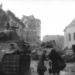 Ez a kép ugyanezt a Mészáros utcai helyszínt mutatja más
szögből. Két nő csomagokkal igyekszik valahova, a szovjet katonák a német harckocsikat vizsgálják. A mai utcaképet ide kattintva nézheti meg.