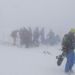 Az elhalasztott snowboard szám résztvevői állnak a sűrű ködben ami ma meghatározta a játékok tempóját