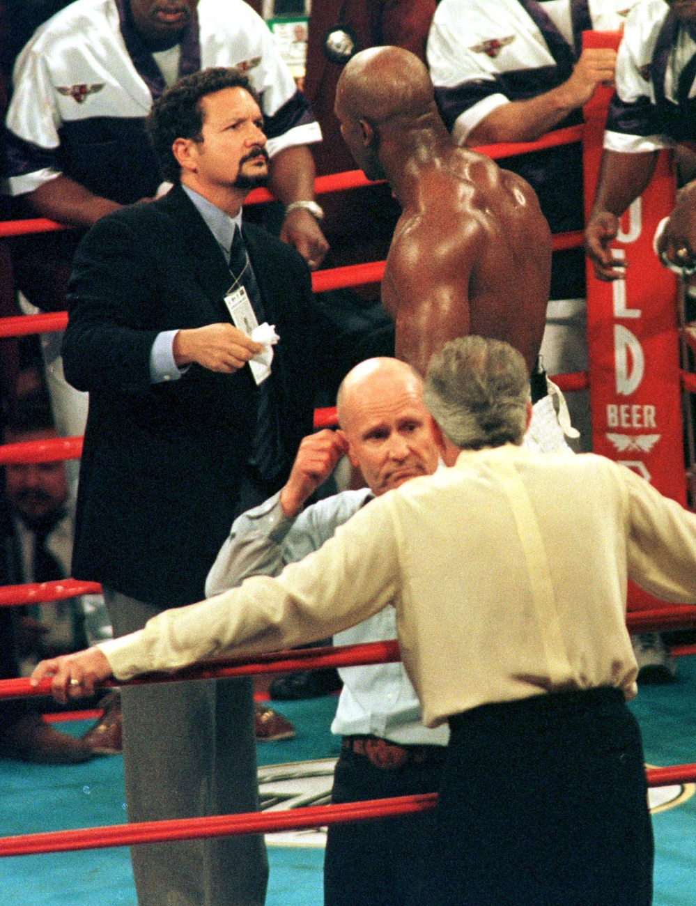 Rendőrök fogják vissza Tysont, miután a bíró őt leléptette és Holyfieldet hirdette ki győztesnek.