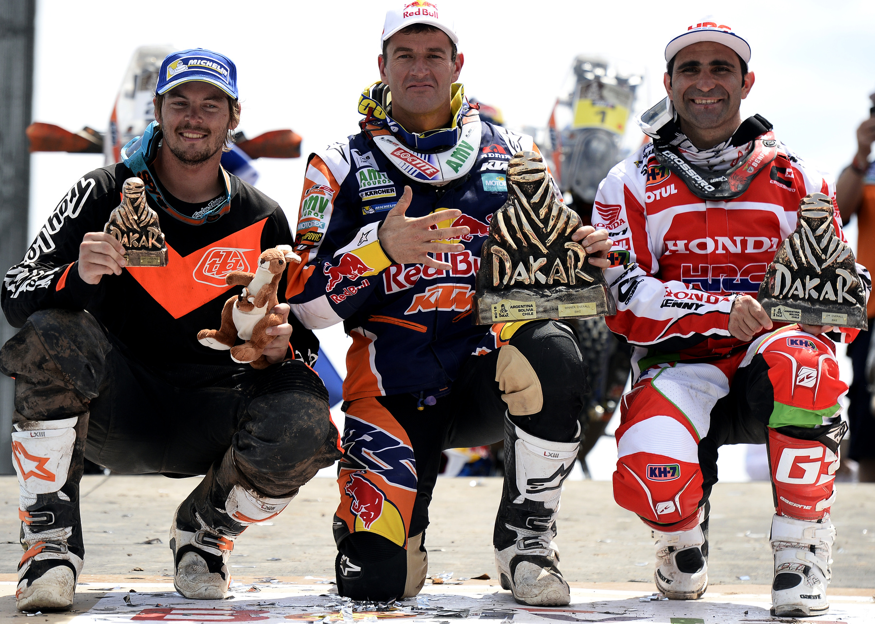 Balról jobbra a motorosok között harmadik Toby Price (Ausztrália), az első Marc Coma (Spanyolország) és a második Paulo Goncalvez (Portugália) a megnyert trófeákkal.