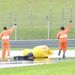 Pályabírók rohannak a pályára az eszméletlenül fekvő Marco Simoncellihez, aki 4 perccel a Moto GP futam startja után szenvedett balesetet