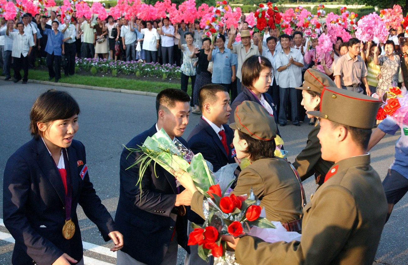 A sportolók azonnal megkoszorúzták Kim Ir Szen és Kim Dzsong Il szobrát.