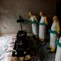 Egyészségügyi dolgozók permetezik egy ebolában elhunyt személy koporsóját a temetésén, Beniben 2018. december 4-én