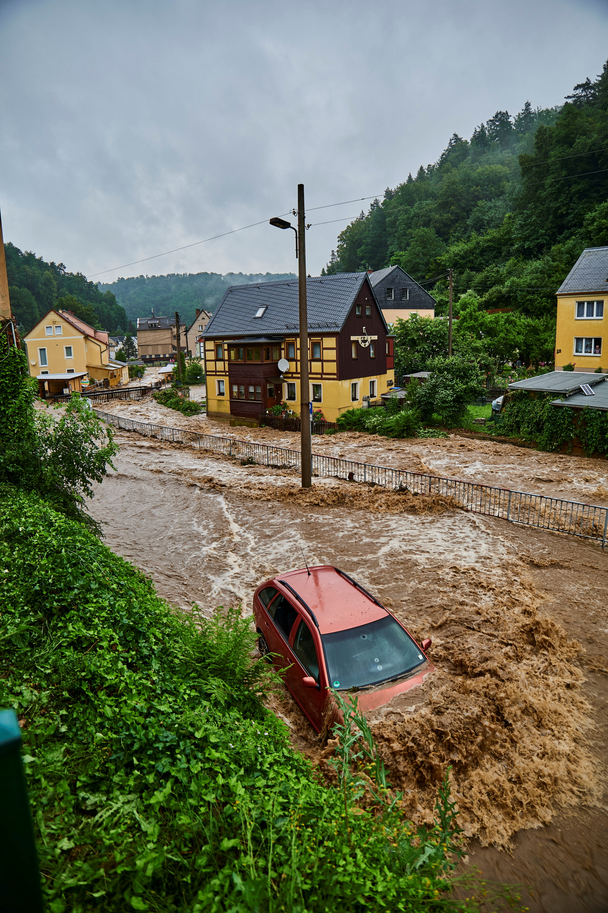 Autók egy vihar után Németországban 2021. július 16-án