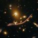 Szép példa a gravitációs lencsehatásra: ebben a sárkányforma alakzatban egyetlen, tízmilliárd fényévnyire levő spirálgalaxisnak (a sárkány feje) a fénye látható.