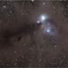 Egy nagyszemű kozmikus szörny - avagy reflexiós ködök és porfelhők játéka a Corona Australis csillagképben. A jobb felső sarokban lévő, NGC 6723 jelű gömbhalmaz majdnem százszor messzebb van a felhőktől.