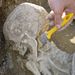 Egy feltárás alatt lévő XI. századi sírban talált csontvázat tisztít az orosházi Szántó Kovács János Területi Múzeum munkatársa. 