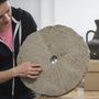 Skriba-Nagy Mónika régész egy vágott malomkövet vizsgál Kecskeméten a Katona József Múzeumban