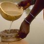 Egy afrikai faluban egy anya szűrővel tisztítja a vizet a fertőzések ellen.

